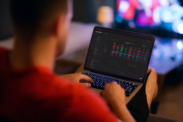 App Móvel 39D — Seu hub completo para cassino e esportes Um homem concentrado em seu laptop com estatísticas ao vivo ao fundo, destacando os recursos dedicados de esportes e jogos do app móvel 39D.